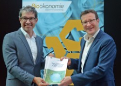 Mr Körner (City of Stuttgart) hands over the urban bioeconomy strategy to State Secretary Dr. Andre Baumann